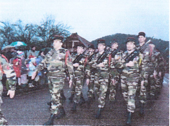 Die Soldaten marschieren an den Einwohnern vorbei