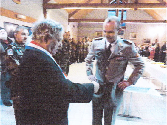 Der Bürgermeister gibt einem Offizier im Saal die Hand